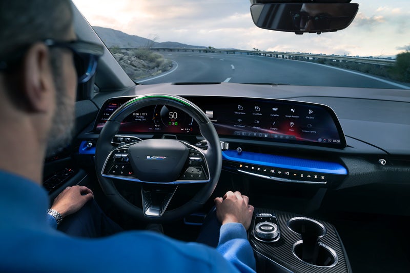 Front View of the 2026 OPTIQ-V Driving Through the Dusk Utilizing its Headlights | Myrtle Beach Cadillac in Myrtle Beach SC