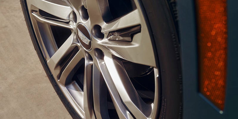 Polished multi-spoke alloy wheel on a Cadillac model