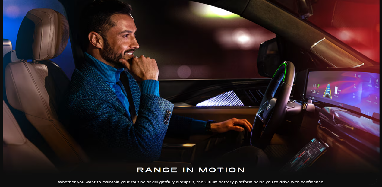 A man driving a car while smiling. Image header says 'Range in motion. Whether you want to maintain your routine or delightfully disrupt it, the Ultimatum battery platform helps you drive with confidence.'
